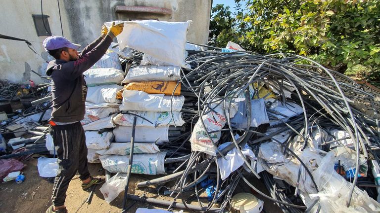 عاملان يجمعان قطع البلاستيك من النفايات تمهيدًا لإعادة تدويرها