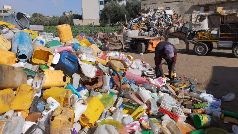 عاملان يجمعان قطع البلاستيك من النفايات تمهيدًا لإعادة تدويرها