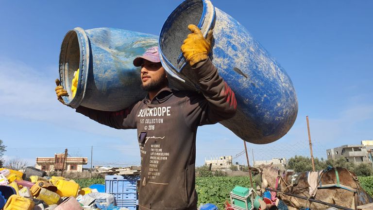 عاملان يجمعان قطع البلاستيك من النفايات تمهيدًا لإعادة تدويرها