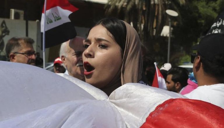 متظاهرة وسط بغداد تحمل علم العراق في الذكرى الثانية لحركة أكتوبر 