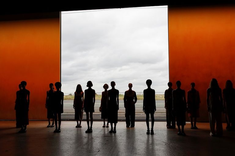 مجموعة من العارضات وفي الخلفية طائرة أثناء الهبوط