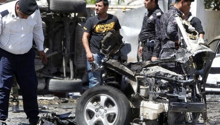 عناصر أمن عراقية بجانب حطام سيارة مفخخة سابقة - أ.ف.ب