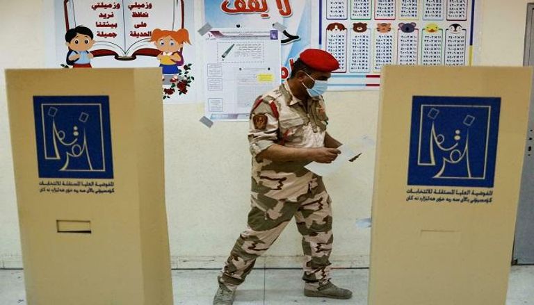 عنصر بالقوى الأمنية خلال الإدلاء بصوته بالانتخابات العراقية- أ.ف.ب