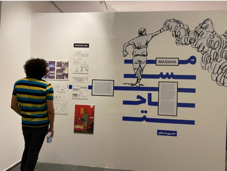 زوار المعرض يشاهدون أحد الأعمال المشاركة