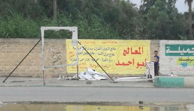 صبي يجمع لافتات مرشحين عقب انتهاء انتخابات سابقة في العراق - أرشيفية