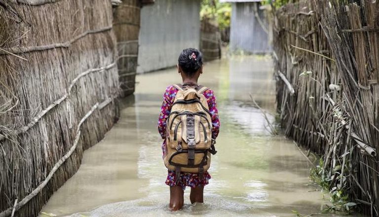 طفلة تمشي وسط مياه السيول