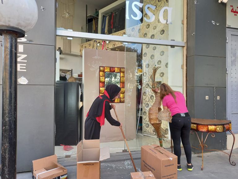 أصحاب محلات يحاولون إصلاح التلفيات