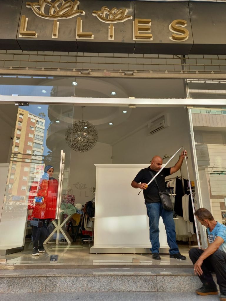 أصحاب محلات يحاولون إصلاح التلفيات