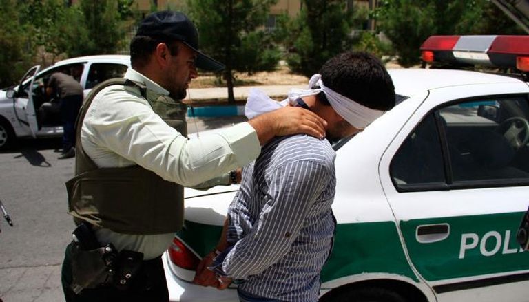  شرطي إيراني يعتقل أحد الأشخاص -أرشيفية