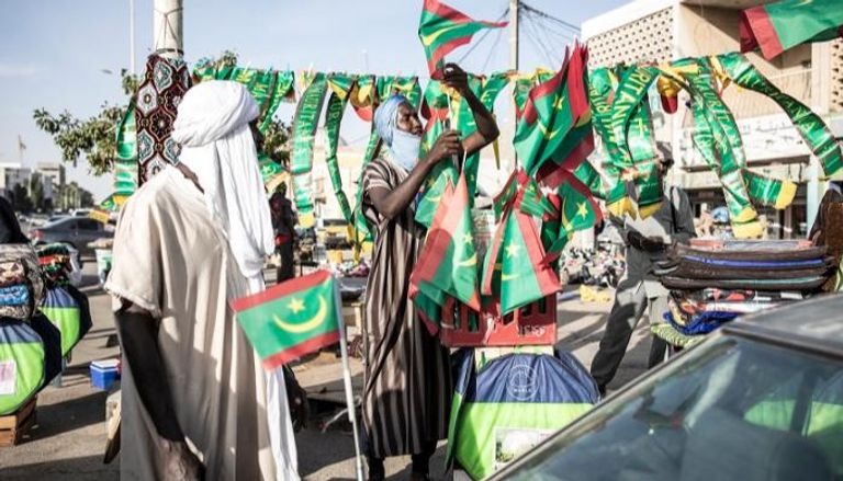 تجار متجولون يعرضون أعلام موريتانيا للبيع (ا ف ب)