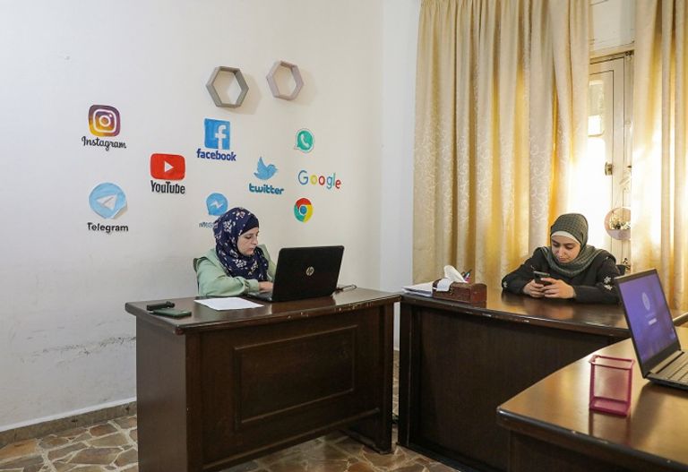 سوريات يعملن في مركز لتصليح الهواتف في إدلب - رويترز