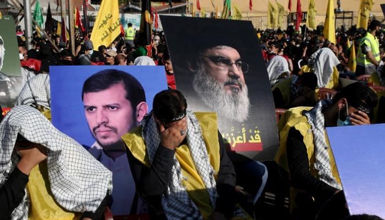 عناصر حزب الله يرفعون صورة لأمينه العام وأخرى للحوثي في بيروت