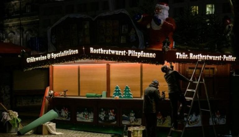 أشخاص يعملون في سوق عيد الميلاد في  دريسدن بألمانيا- أ ف ب