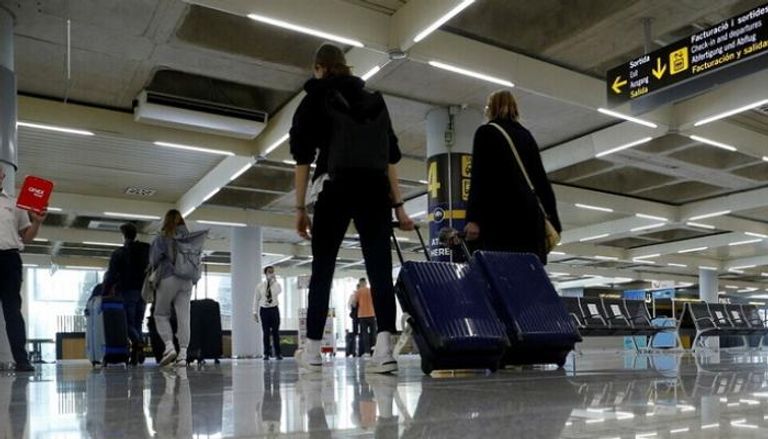 مسافرون في أحد مطارات إسبانيا- رويترز
