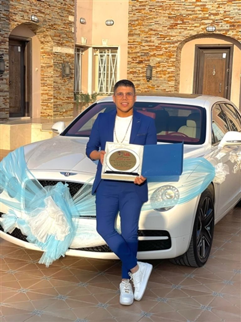 مطرب المهرجانات المصري عمر كمال إلى جوار السيارة 