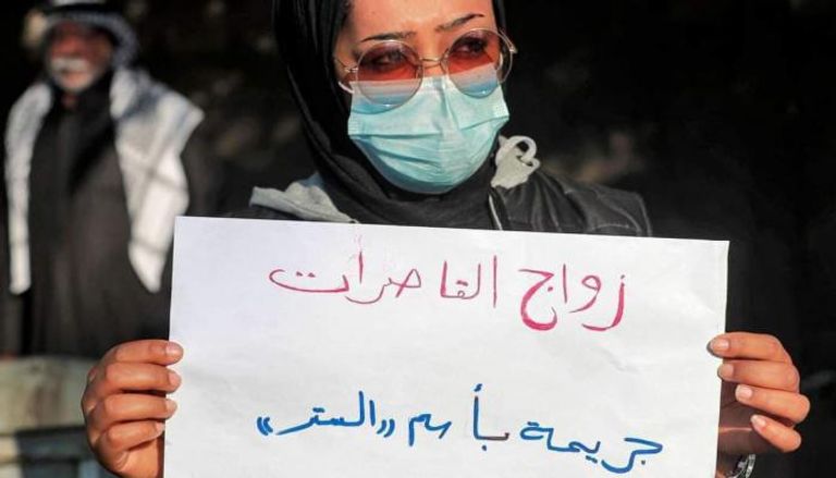 ناشطة نسوية تتظاهر أمام محكمة عراقية احتجاجا على زواج قاصرة