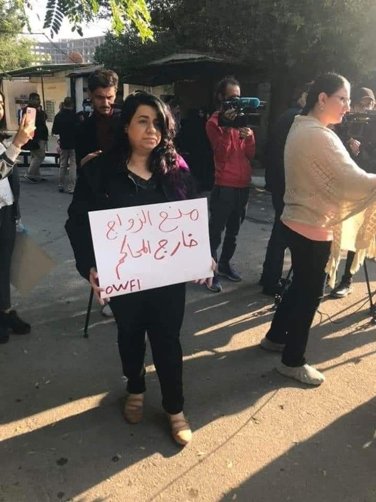ناشطة نسوية تتظاهر أمام محكمة عراقية احتجاجا على زواج قاصرة