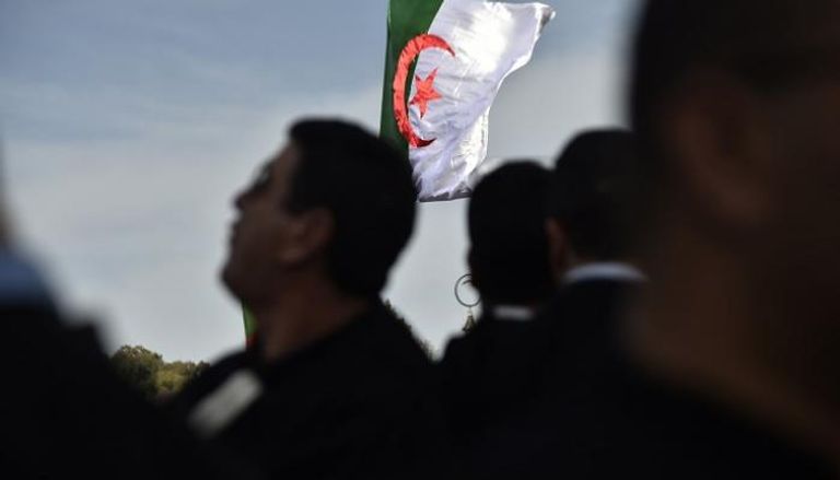 جزائريون يتوسطون علم بلدهم - أرشيفية