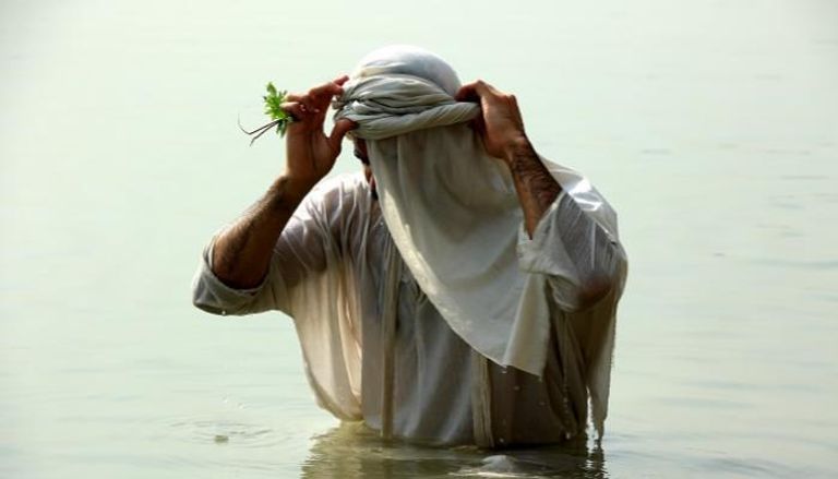 أحد أتباع طائفة الصابئة المندائيين في نهر دجلة خلال طقوس تطهير 