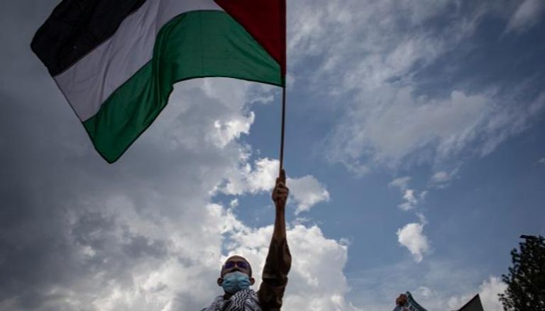 شاب فلسطيني يرفع علام بلاده خلال فعالية في جنوب أفريقيا