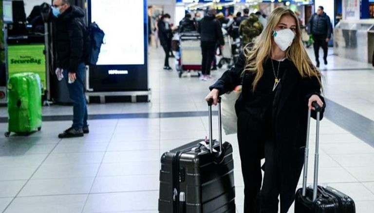 امرأة ترتدي كمامة بأحد مطارات سويسرا