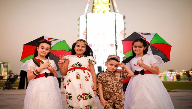 أطفال بالزي الإماراتي في استقبال الزوار