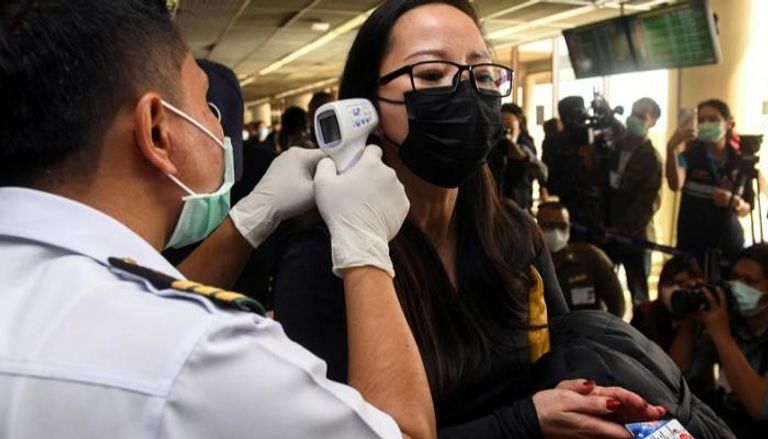 قياس حرارة لامرأة بأحد مطارات تايلاند