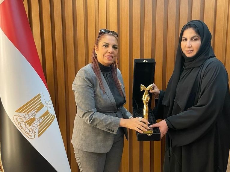 استلمت الجائزة نيابةً عن الشيخة فاطمة بنت مبارك، نورة السويدي، الأمينة العامة للاتحاد النسائي العام، في جناح جمهورية مصر العربية في إكسبو 2020 دبي شعار الشيخة فاطمة بنت مبارك