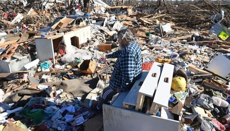 مسن يجلس على ركام منزل دمرته الأعاصير في أمريكا