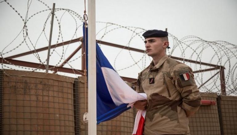 جندي فرنسي خلال مراسم إنزال علم بلاده من قاعدة عسكرية بمالي- أ.ف.ب