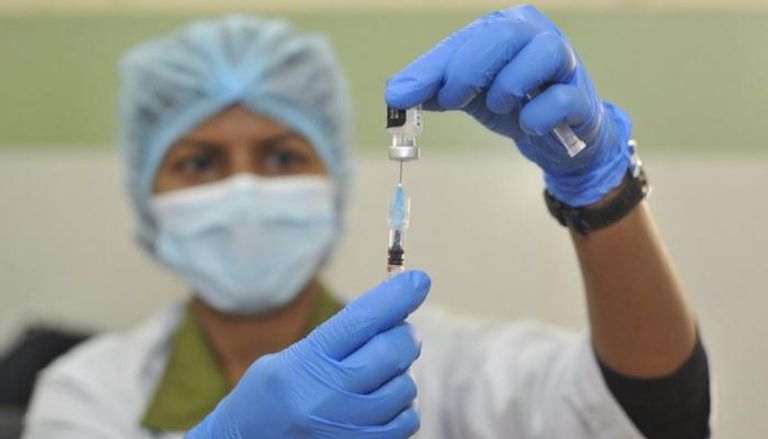 عامل صحية تجهز جرعة للقاح كورونا