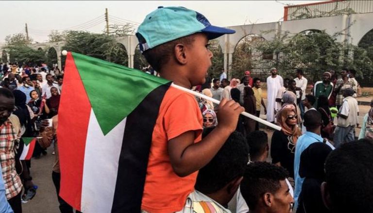 طفل سوداني يحمل علم بلاده خلال مظاهرات سابقة بالخرطوم