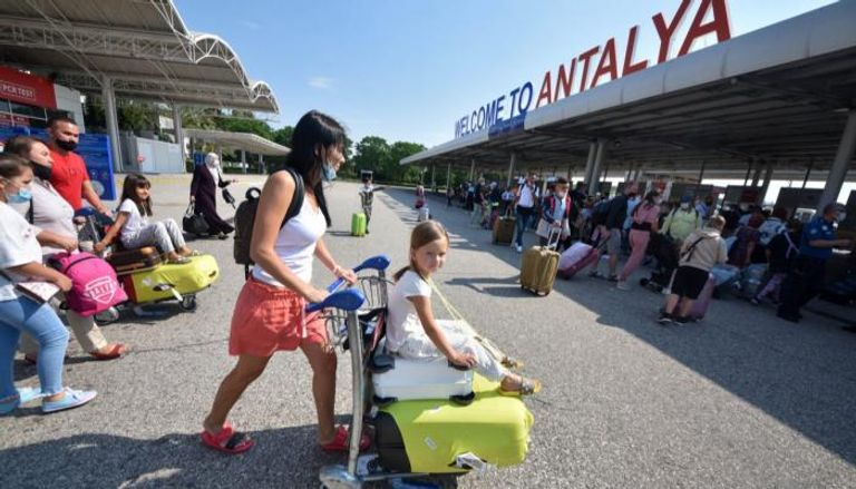 عدد من السياح أمام مطار أنطاليا