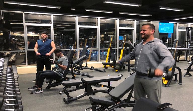 شخص يرتدي كمامة أثناء تواجده في صالة رياضية