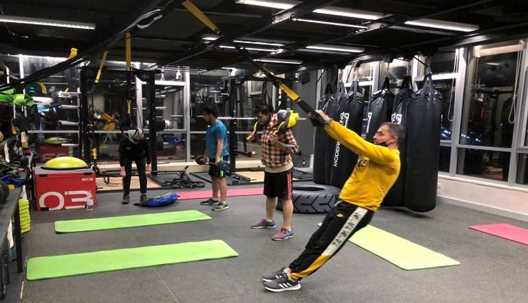 شخص يرتدي كمامة أثناء تواجده في صالة رياضية