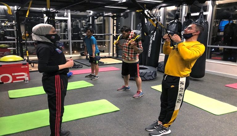 شخص يرتدي كمامة أثناء تواجده في صالة رياضية