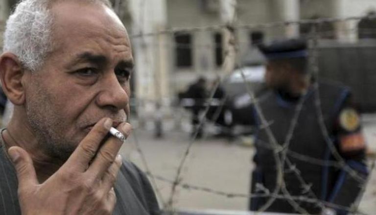 مصري يدخن سيجارة بأحد شوارع القاهرة - رويترز