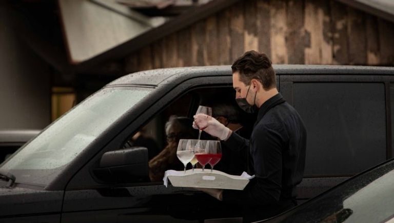 العروسان أثناء تحيتهما للضيوف الجالسين داخل سياراتهم