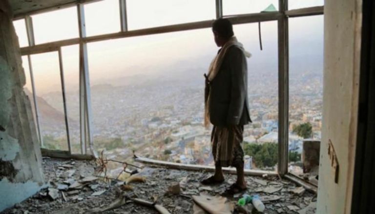 يمني في شرفة مدمرة مطلة على تعز معقل فوضى 11 فبراير