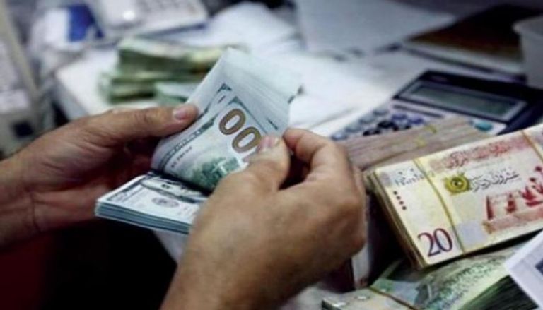 موظف بأحد مصارف ليبيا يحصي عملات من فئة 100 دولار