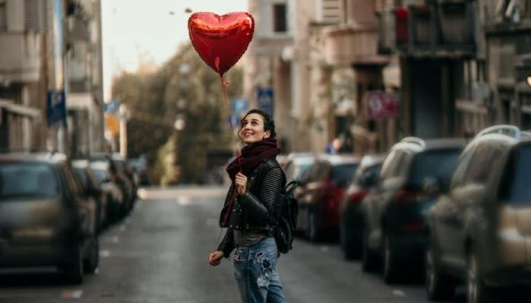 فتاة تحمل قلبا أحمر في عيد الحب