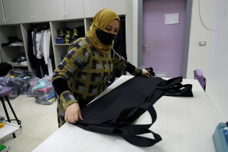 امرأة تطوي كيسا معدا لجثث ضحايا كوفيد-19 في مشغل الأم في مدينة صيدا الساحلية جنوب لبنان امرأة تخيط كيسا معدا لدفن موتى كورونا في مشغل الأم بمدينة صيدا جنوب لبنان