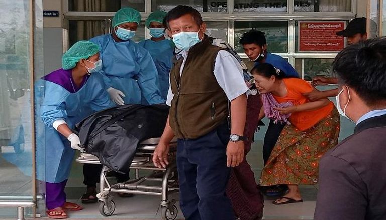 فريق طبي يحمل جثة الشابة ميا ثواتي ثواتي خاينج