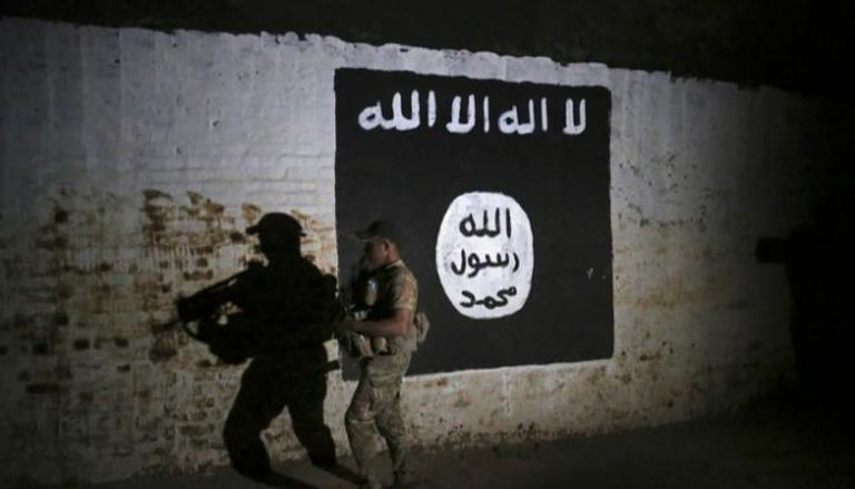 جندي عراقي يتفقد نفقا بداخله علم داعش - الفرنسية