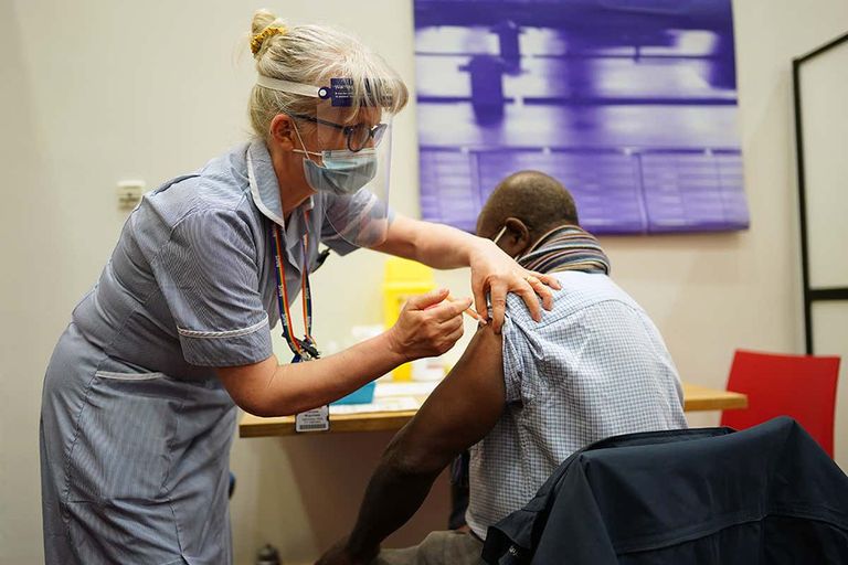 كورونا حول العالم امرأة تضبط الكمامة على وجه طفل