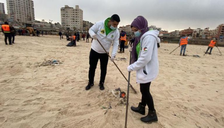 متطوعون يشاركون بتنظيف شاطئ غزة