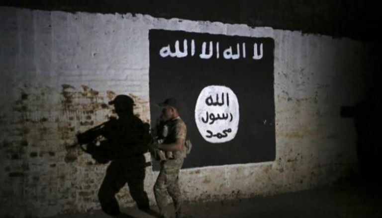 جندي عراقي يتفقد نفقا بداخله علم داعش - الفرنسية