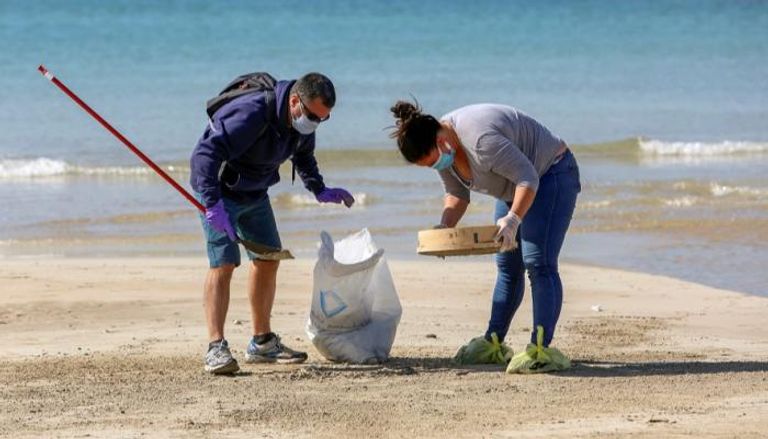 لبنانيان متطوعان خلال الحملة على شاطئ صور