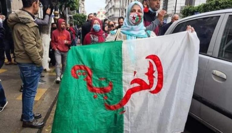 جزائرية ترفع علم البلاد في ذكرى الحراك الشعبي