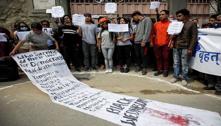 متظاهرة في ميانمار على الأرض تعبيرا عن رفضها للانقلاب